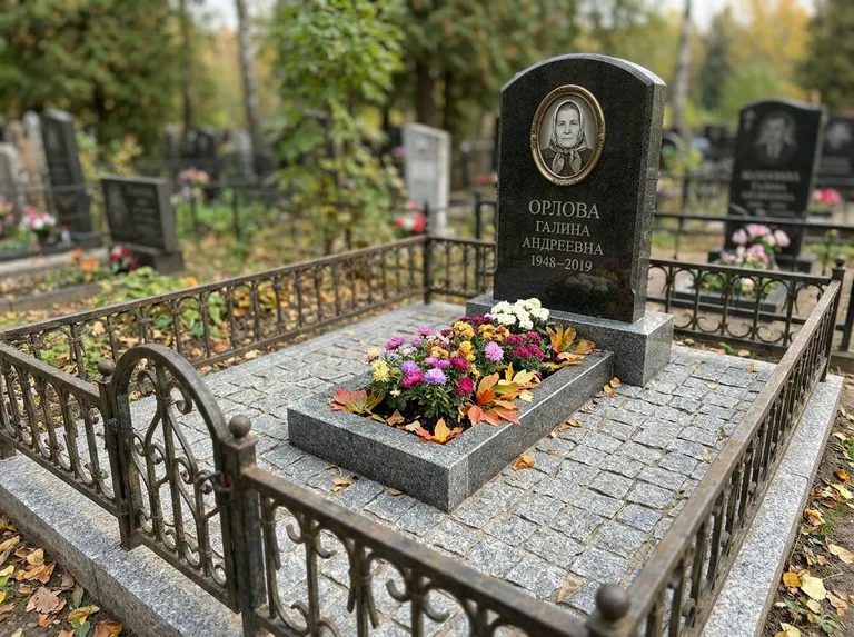 Благоустроенное захоронение с гранитной плиткой, оградой и цветником в Иркутске