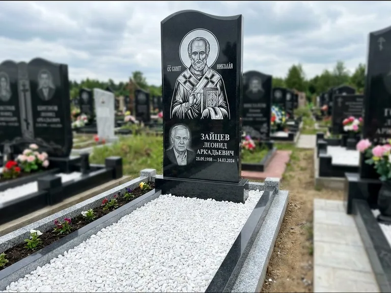 Памятник с гравировкой иконы: стела с крестообразным навершием — икона в резной рамке-киоте, газон без ограды, стриженая трава, работа «Раевская» в Иркутске