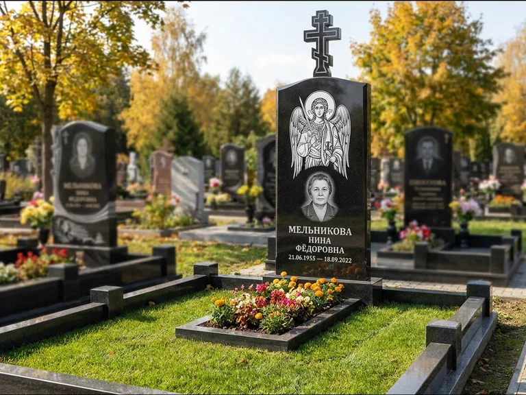 Памятник с гравировкой иконы: округлая стела-медальон с ликом — гравировка Богородицы «Семистрельная», луговые травы и полевые цветы за участком, работа «Гущин» в Иркутске