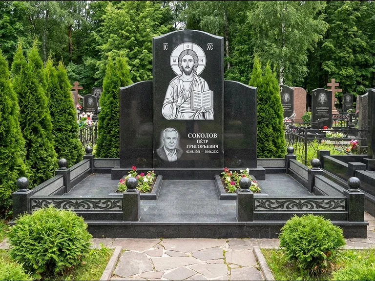 Памятник с гравировкой иконы: широкая горизонтальная лежачая плита-стела — икона в резной рамке-киоте, серая гравийная отсыпка с бордюром, работа «Богданова» в Иркутске