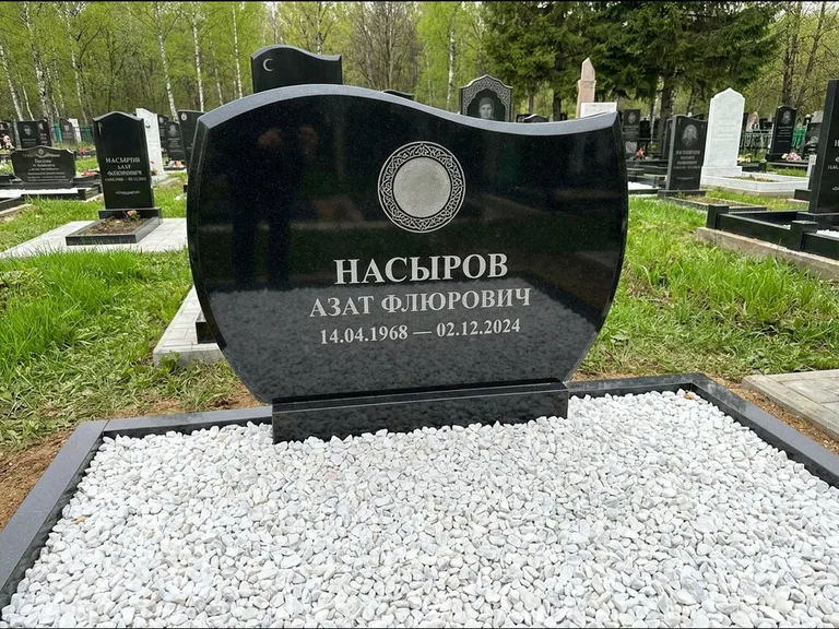 Мусульманский памятник: стела с волнообразным скошенным верхом — гравировка мечети под полумесяцем и звёздами, белая мраморная крошка с бордюром, работа «Насыров» в Иркутске