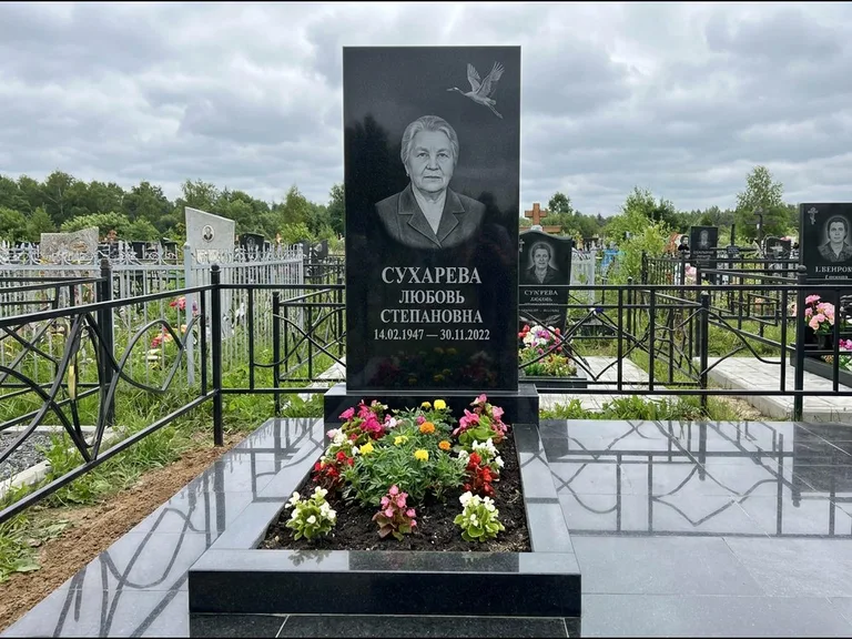 Памятник с гравировкой журавлей — гравировка одиночного летящего журавля над портретом, работа «Сухарева» в Иркутске