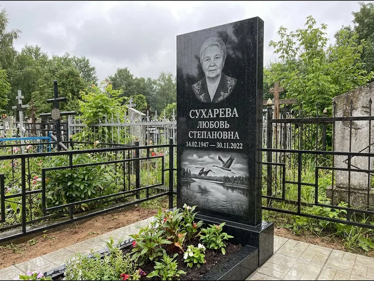 Памятник с гравировкой журавлей — гравировка пары журавлей над гладью озера в нижней части, работа «Сухарева» в Иркутске