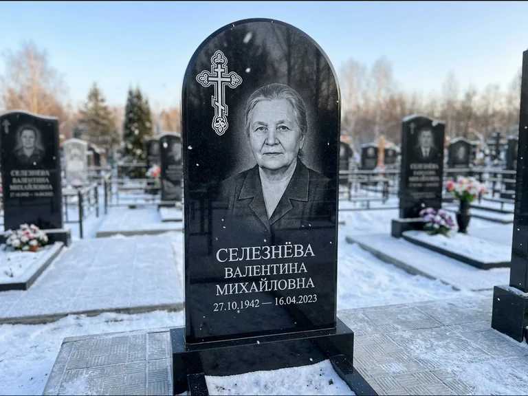 Памятник из чёрного гранита — массивная стела с крестом в лучах с крестом в лучах, работа «Одинцова» в Иркутске